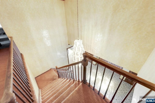 stairs with a chandelier