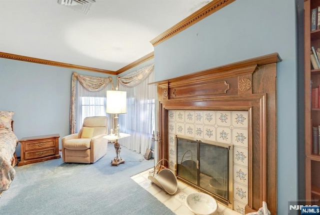 sitting room with a tiled fireplace, carpet flooring, crown molding, and visible vents