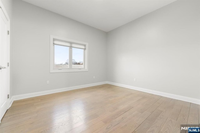 spare room featuring light wood-style floors and baseboards