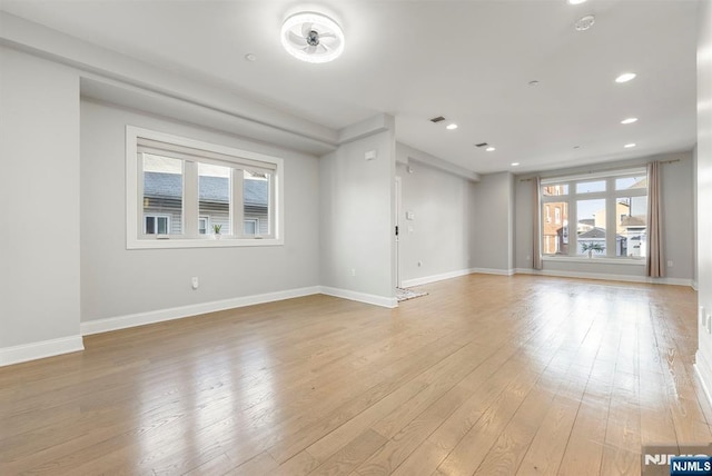 empty room featuring recessed lighting, light wood-type flooring, visible vents, and baseboards