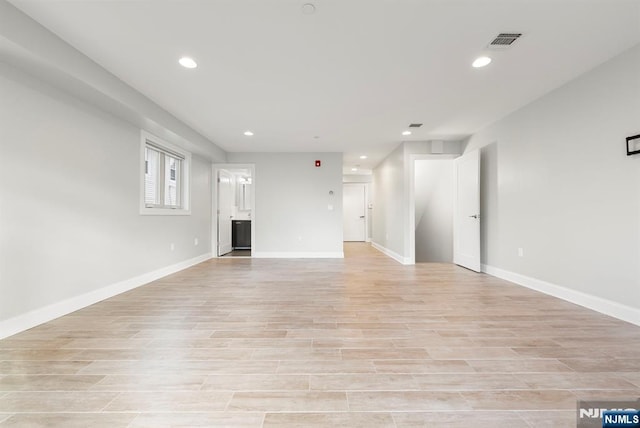 unfurnished living room with light wood finished floors, baseboards, and recessed lighting