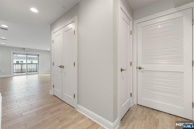 hallway with light wood-type flooring, visible vents, baseboards, and recessed lighting