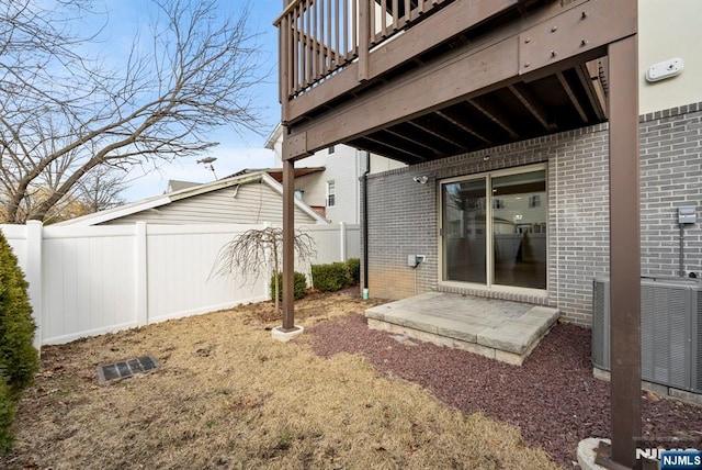 exterior space featuring a patio area, fence, and central AC unit