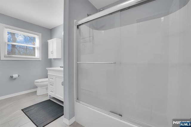 bathroom with toilet, vanity, baseboards, and tile patterned floors