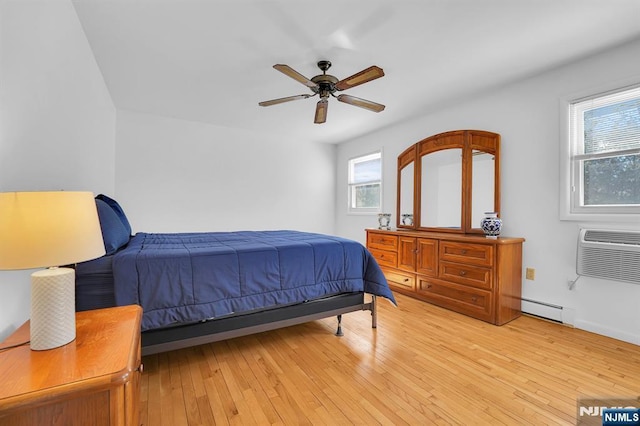 bedroom featuring light wood-style floors, a baseboard radiator, an AC wall unit, and a ceiling fan