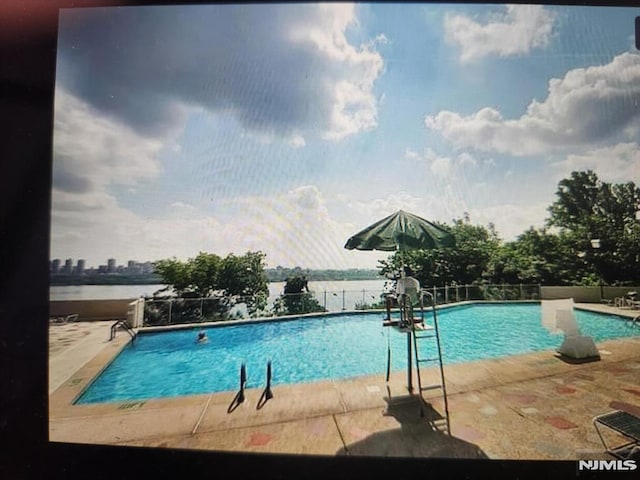 pool featuring fence and a patio