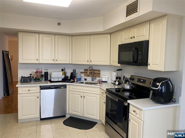 kitchen with visible vents, a sink, light countertops, appliances with stainless steel finishes, and a textured ceiling