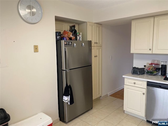 kitchen with light tile patterned floors, white cabinets, stainless steel appliances, and light countertops