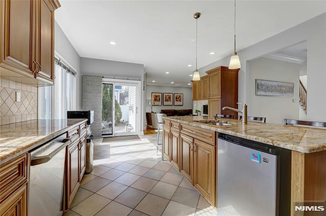 kitchen with a kitchen island with sink, light stone counters, tasteful backsplash, stainless steel dishwasher, and dishwashing machine