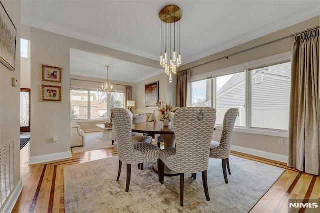 dining space featuring crown molding, a notable chandelier, and baseboards