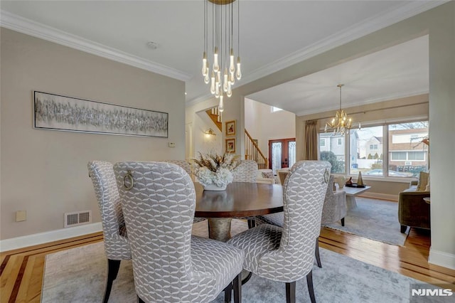 dining room with visible vents, baseboards, a chandelier, ornamental molding, and wood finished floors