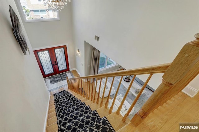 entrance foyer featuring stairway, a healthy amount of sunlight, visible vents, and wood finished floors