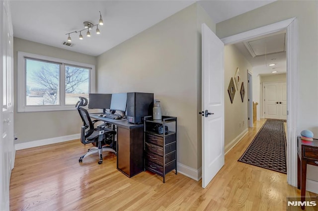 office area featuring visible vents, baseboards, light wood-style floors, and attic access