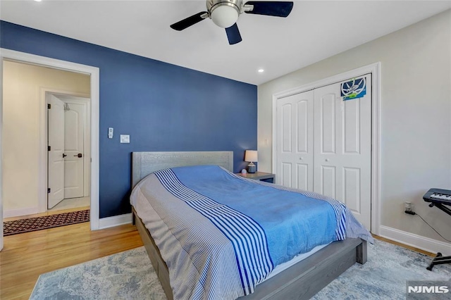 bedroom with a ceiling fan, wood finished floors, baseboards, recessed lighting, and a closet