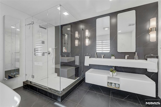 full bathroom featuring vanity, tile walls, marble finish floor, and a shower stall