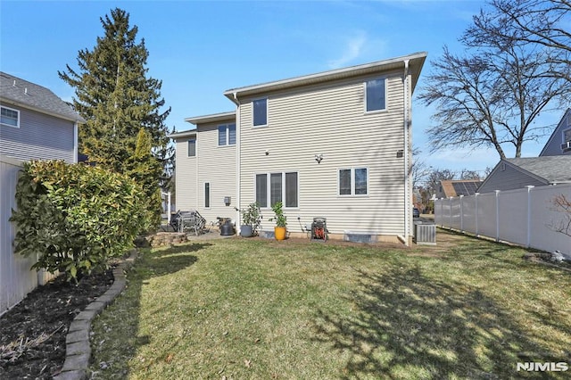 rear view of house with a lawn, central AC, and fence