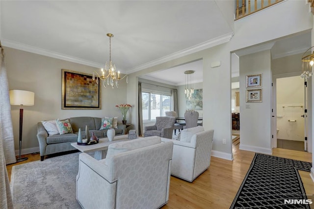 living area with light wood-type flooring, baseboards, an inviting chandelier, and ornamental molding