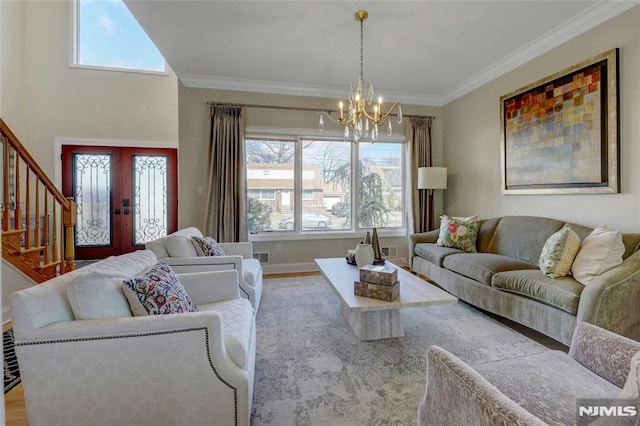 living area featuring stairway, wood finished floors, crown molding, and french doors