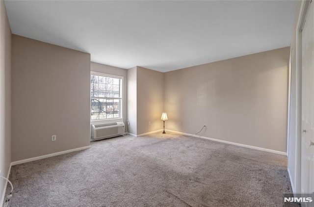 carpeted empty room featuring baseboards and a wall mounted air conditioner