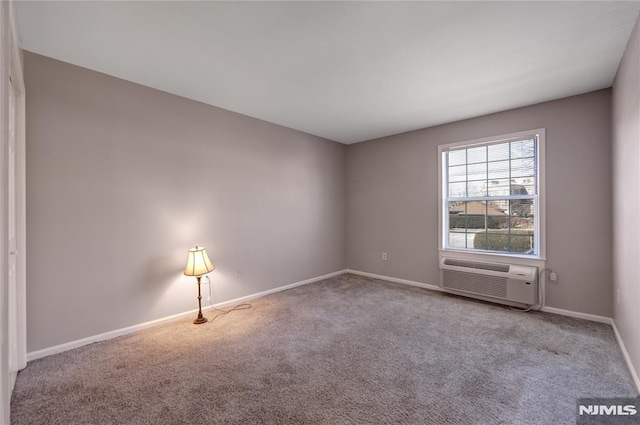 carpeted spare room featuring baseboards and a wall mounted air conditioner