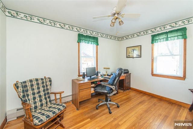 office featuring light wood-style flooring, plenty of natural light, a ceiling fan, and baseboards