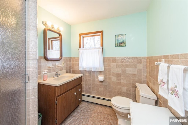 bathroom featuring toilet, a stall shower, tile walls, a baseboard radiator, and vanity