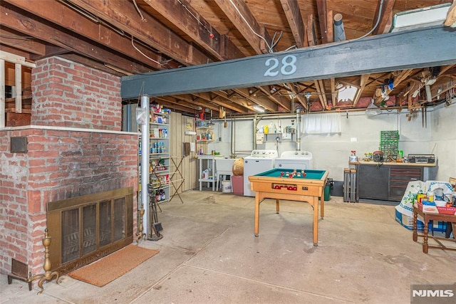 unfinished below grade area featuring washer and dryer and a brick fireplace