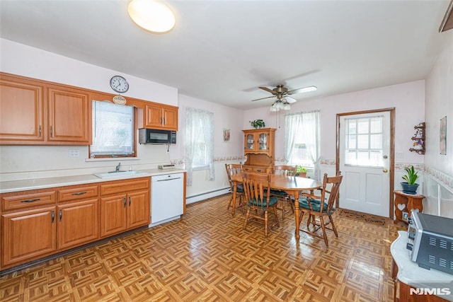 kitchen with black microwave, dishwasher, a baseboard radiator, light countertops, and a sink