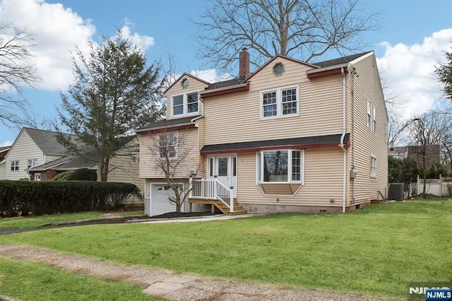 view of front of home featuring central AC unit, fence, an attached garage, a chimney, and a front lawn