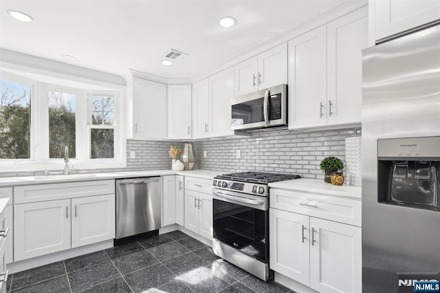 kitchen featuring granite finish floor, recessed lighting, appliances with stainless steel finishes, and a sink