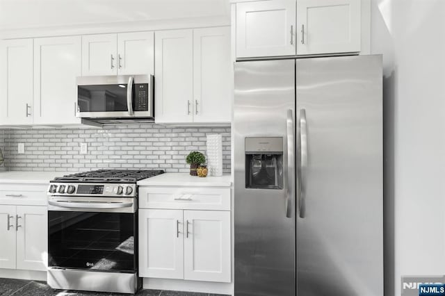 kitchen featuring tasteful backsplash, appliances with stainless steel finishes, white cabinetry, and light countertops