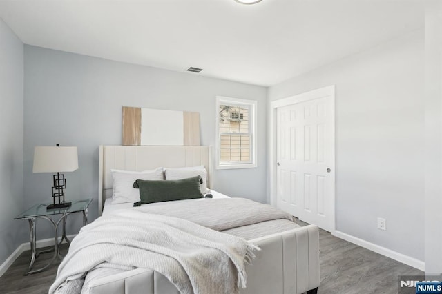 bedroom featuring a closet, baseboards, and wood finished floors