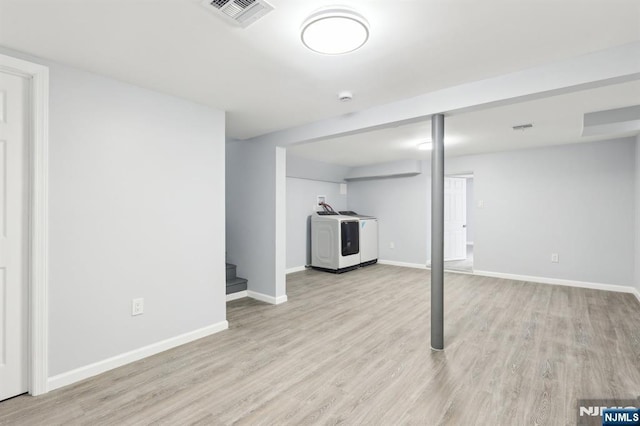 finished basement with visible vents, baseboards, light wood-style flooring, and stairway