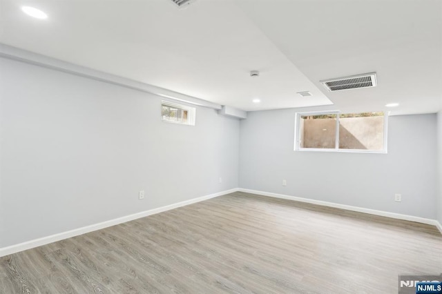 below grade area with visible vents, baseboards, and wood finished floors