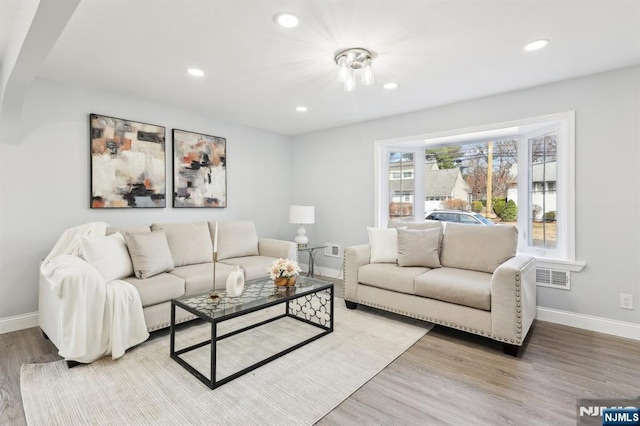 living room featuring recessed lighting, light wood-type flooring, and baseboards