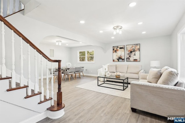 living area featuring recessed lighting, baseboards, light wood-style floors, and stairs