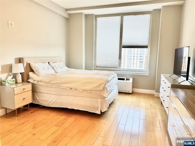 bedroom featuring baseboards and light wood-style floors