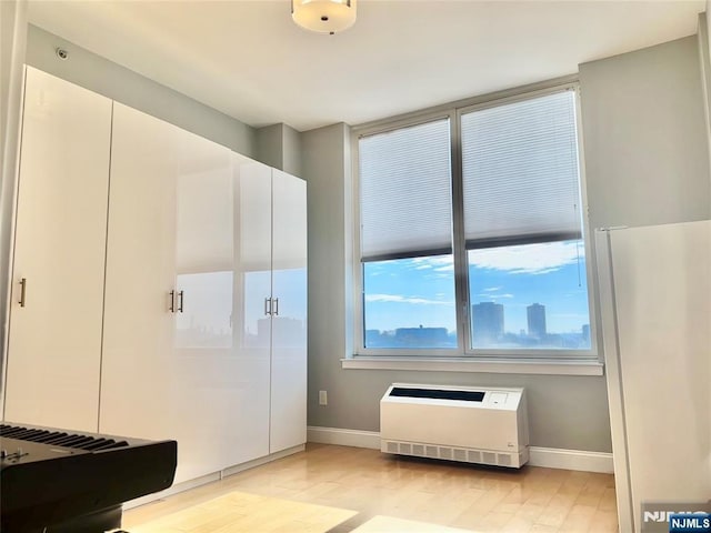 interior space featuring light wood-type flooring, baseboards, and heating unit