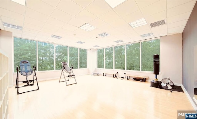 exercise room featuring visible vents, a drop ceiling, and wood finished floors