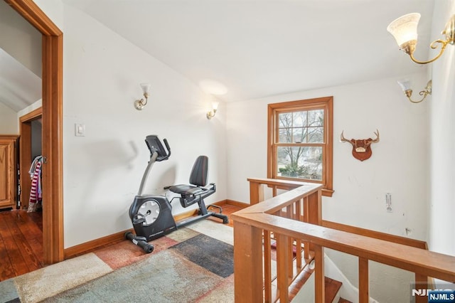 workout area with lofted ceiling, baseboards, and a chandelier