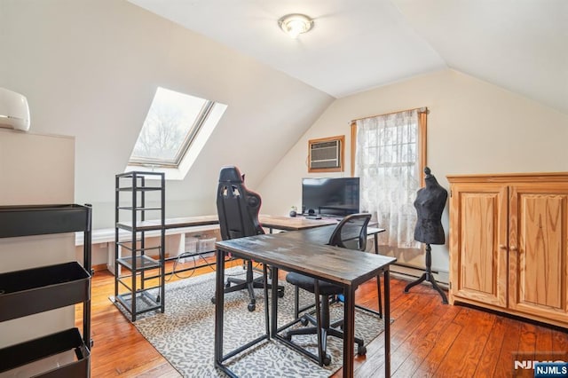 office area featuring lofted ceiling with skylight, an AC wall unit, a wall unit AC, and wood-type flooring