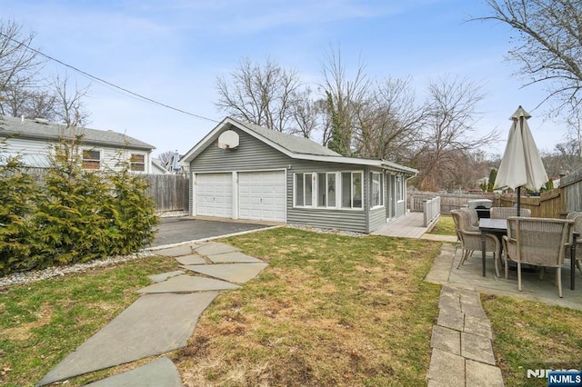 exterior space with a garage, outdoor dining area, a front yard, and fence