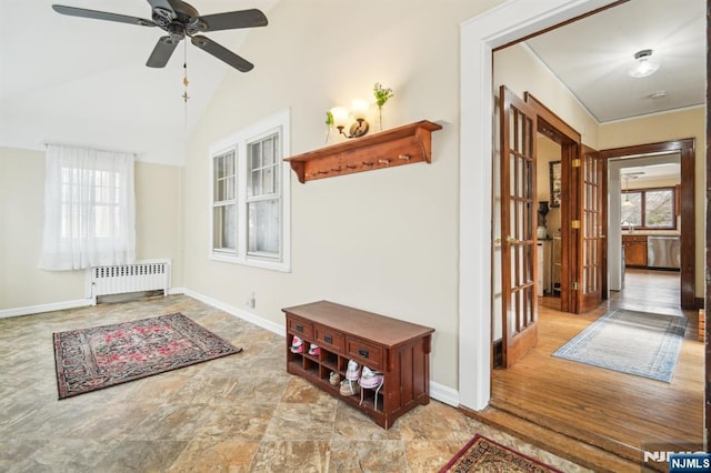 interior space featuring baseboards, lofted ceiling, and radiator