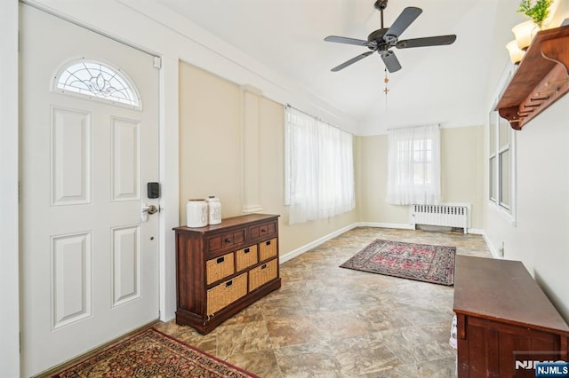 entryway with stone finish floor, radiator heating unit, a ceiling fan, and baseboards