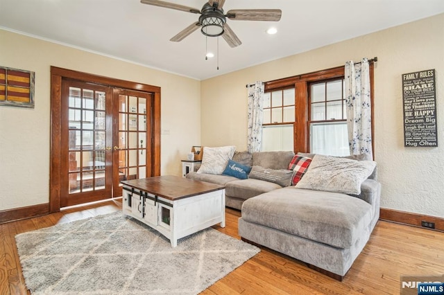 living room with light wood-style flooring, a ceiling fan, recessed lighting, french doors, and baseboards