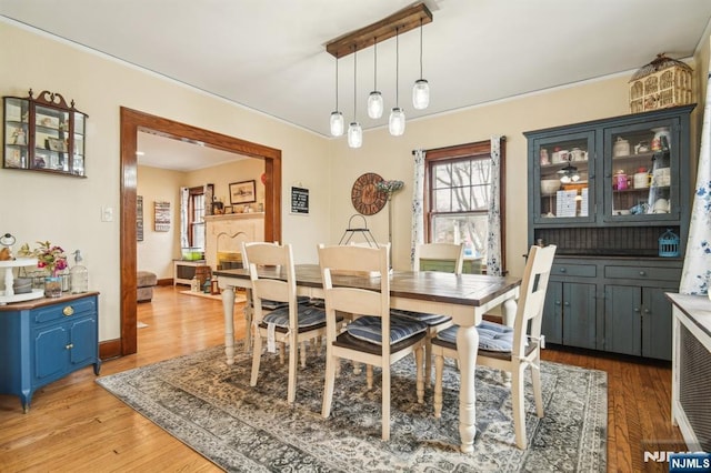 dining space with baseboards and light wood-style floors