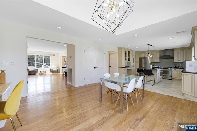 dining area with recessed lighting, a notable chandelier, visible vents, baseboards, and light wood-type flooring