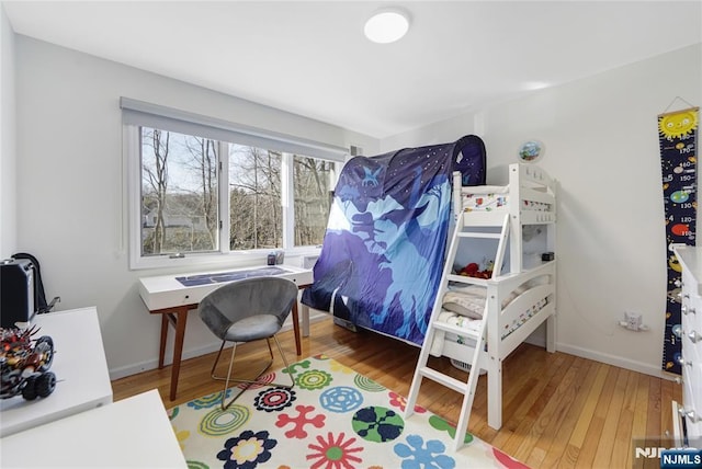 bedroom with baseboards and wood finished floors