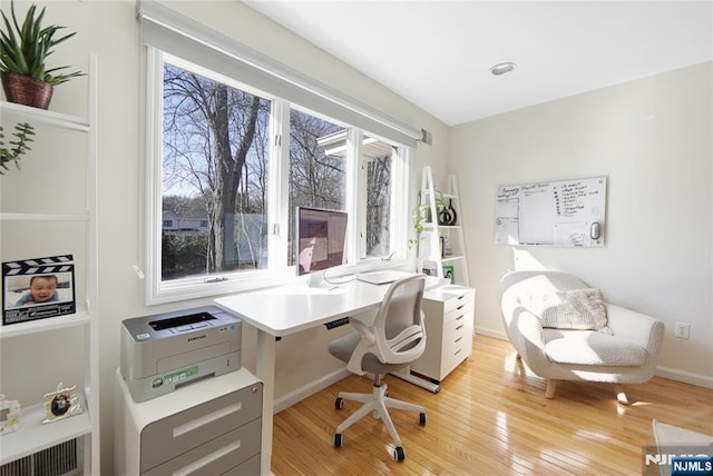 home office featuring light wood-type flooring, visible vents, and baseboards