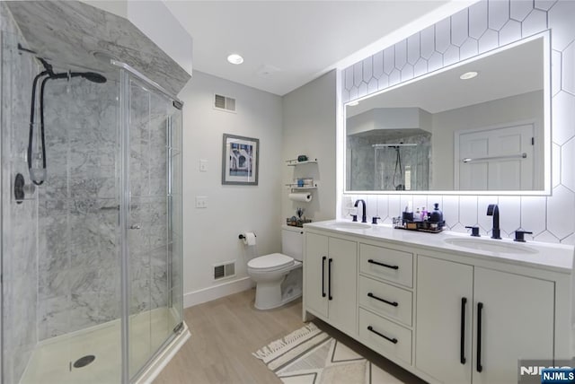 full bathroom featuring visible vents, a sink, a shower stall, and toilet